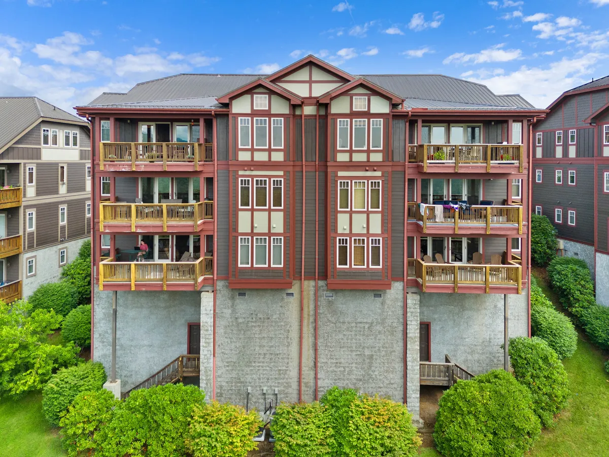 A vibrant exterior image featuring colorful flower beds, multiple balconies, and inviting architectural details. The scene suggests a welcoming environment for gathering outdoors and relaxing after a day of exploring.