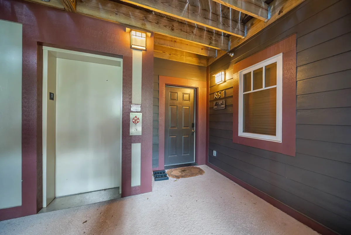 This image presents the main entrance of the property, featuring an inviting door, accessible elevator, and warm decorative lighting. The entryway sets the tone for welcoming group arrivals, milestone celebrations, or simply the anticipation of a memorable stay with friends or family.
